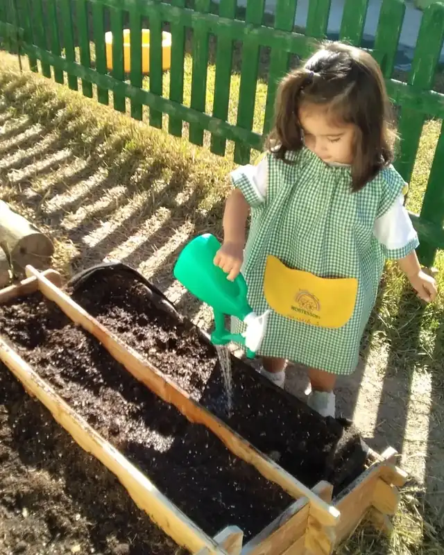 Niña regando el huerto ecológico
