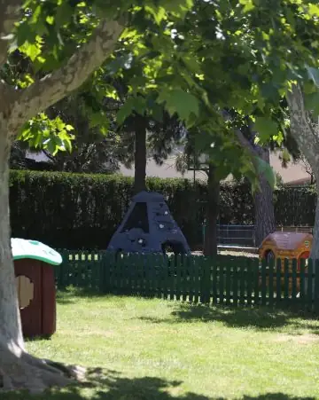 Jardín con árboles y casita de juegos